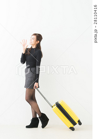 スーツケースを引く女性の写真素材