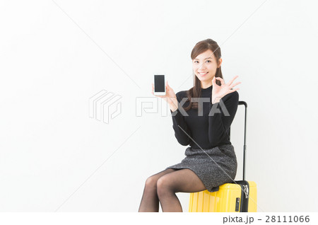 スーツケースに座る女性の写真素材
