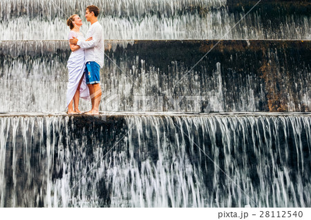 Family honeymoon holiday. Couple in waterfall pool 28112540