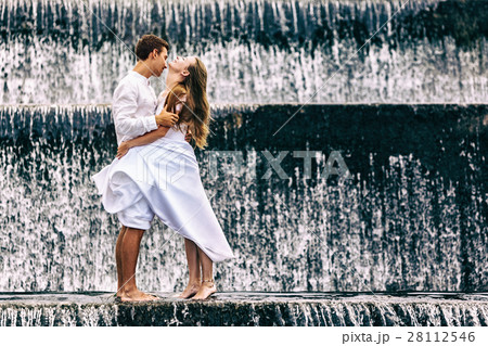 Family honeymoon holiday. Couple in waterfall pool 28112546