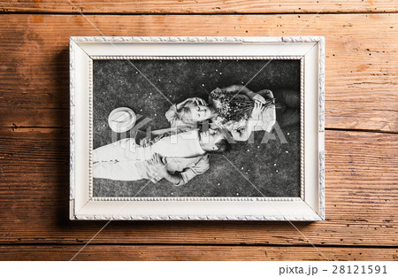 Photo of seniors in picture frame laid on wooden Photo of seniors in picture frame laid on wooden 28121591