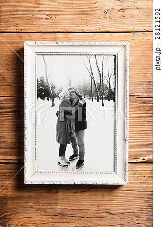 Photo of seniors in picture frame laid on wooden Photo of seniors in picture frame laid on wooden 28121592
