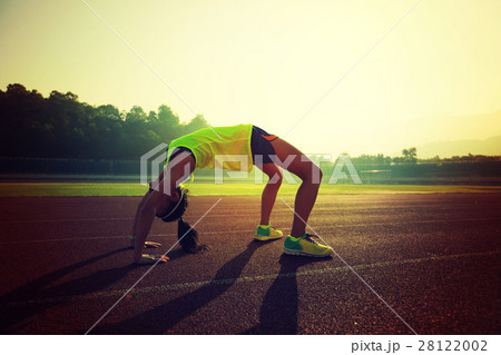young asian woman backbending on stadium track 28122002