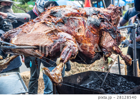 great beef cooked on a spit in the outdoor great beef cooked on a spit in the outdoor 28128540