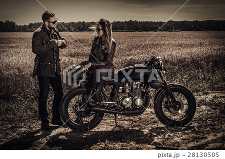 Young, stylish cafe racer couple on vintage custom Young, stylish cafe racer couple on vintage custom 28130505