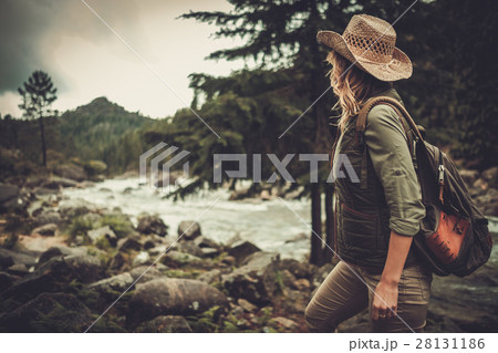 Beautiful woman hiker near wild mountain river 28131186