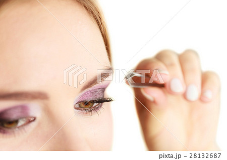 Woman tweezing eyebrows plucking with tweezers Woman tweezing eyebrows plucking with tweezers 28132687
