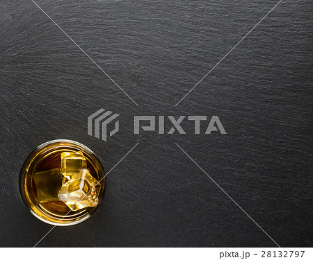 Glass of whiskey with ice on a black background Glass of whiskey with ice on a black background 28132797