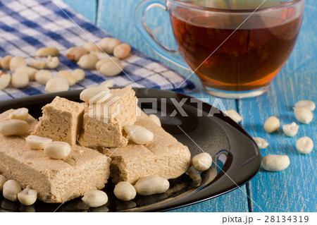 peanut halva in the plate on a blue wooden 28134319