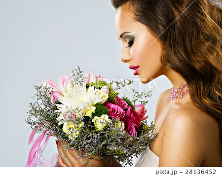 Portrait Of Beautiful Girl With Flowers In Handsの写真素材