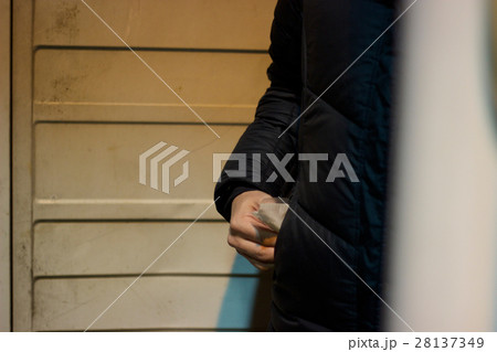 路地裏で潜む覚醒剤・コカインなど危険ドラッグなど粉末状の薬物を隠す男のイメージ写真素材 28137349