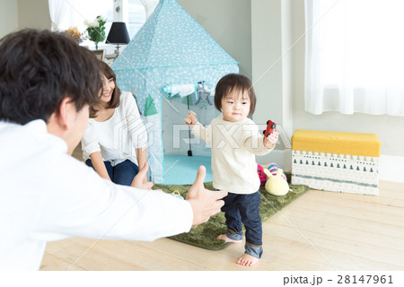 3人家族 休日 赤ちゃん 立っち おいでおいでの写真素材