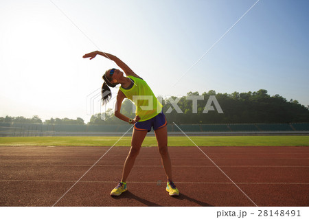 Young woman runner stretching before run Young woman runner stretching before run 28148491