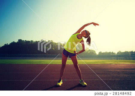 Young woman runner stretching before run   28148492