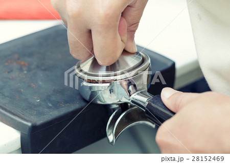 Hands of professional barista supplying coffee 28152469