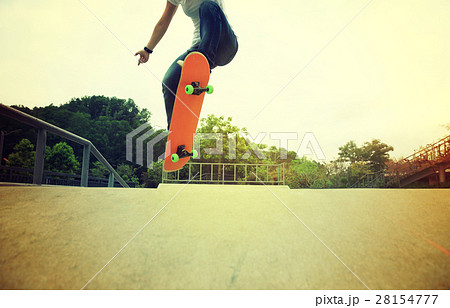 skateboarder legs doing a ollie trick at skatepark 28154777