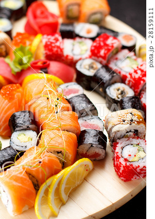 Sushi set on a wooden plate and black concrete Sushi set on a wooden plate and black concrete 28159111
