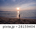 夕陽をバックに海辺を走る少年 28159404