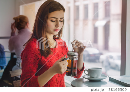 Young girl pours black tea from glass kettle 28166509