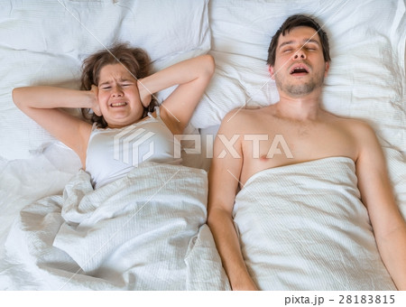 Young woman is lying with her husband in bed. 28183815