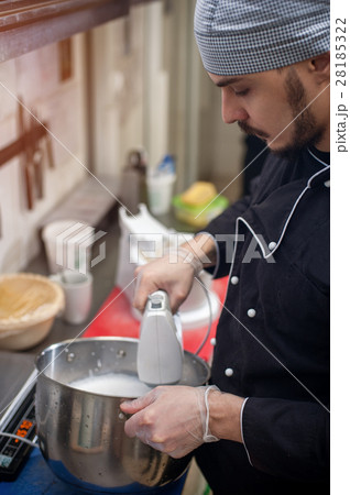 Male bearded cook preparing cream using mixer Male bearded cook preparing cream using mixer 28185322