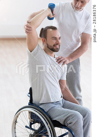 Delighted disabled man exercising with his 28186376