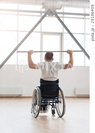 Skilled young disabled man exercising with weights Skilled young disabled man exercising with weights 28186409