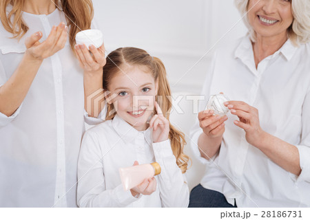 Little girl using beauty cream. Little girl using beauty cream. 28186731