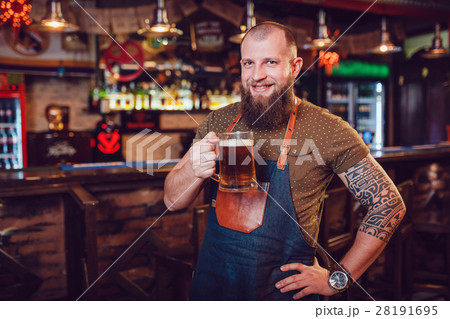Bearded barman with tattoos wearing an apron Bearded barman with tattoos wearing an apron 28191695