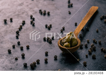 Vintage wooden spoon with capers on dark tray Vintage wooden spoon with capers on dark tray 28193408