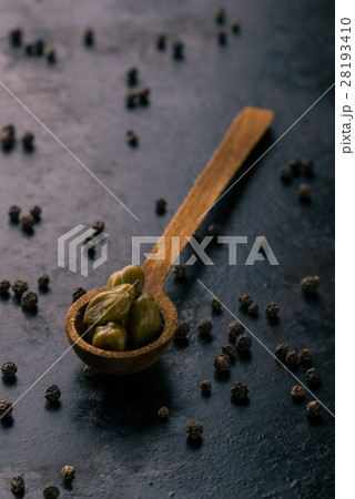 Vintage wooden spoon with several pieces of capers 28193410