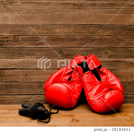 Two red boxing gloves lie on a wooden background 28193621