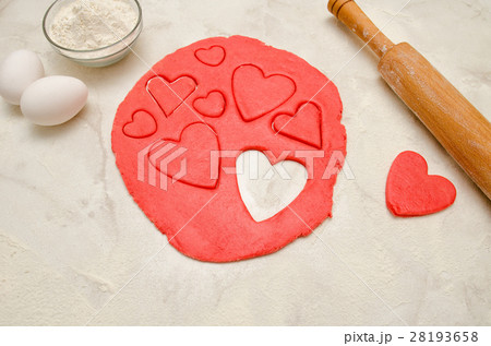 Red dough with a rolling pin and cut out hearts Red dough with a rolling pin and cut out hearts 28193658