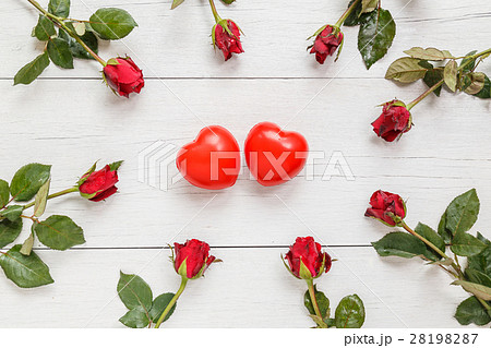 Fresh red rose flower and two red heart on white wooden deck with empty space for design. For love or valentine day concept Fresh red rose flower and two red heart on white wooden deck with empty space for design. For love or valentine day concept 28198287