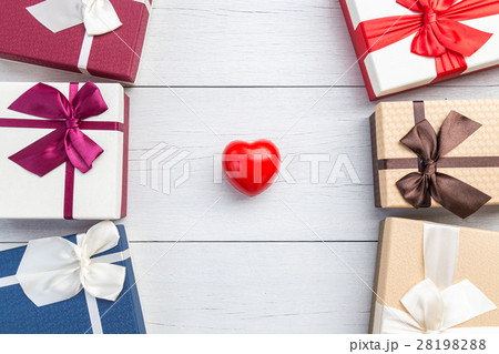 Top view red heart and gift box with ribbon on white wooden plank. For love or valentine day concept Top view red heart and gift box with ribbon on white wooden plank. For love or valentine day concept 28198288