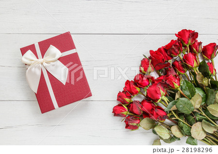 Fresh red rose flower and gift box on white wooden deck with empty space for design. For love or valentine day concept Fresh red rose flower and gift box on white wooden deck with empty space for design. For love or valentine day concept 28198296