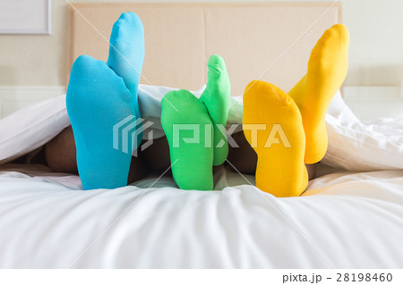 Foots of family with color sock on the bed 28198460