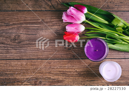 Pink Tulip Flowers and two cendels on rustic table Pink Tulip Flowers and two cendels on rustic table 28227530