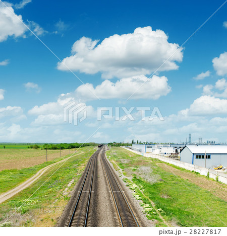 two railroads in green landscape under blue sky 28227817
