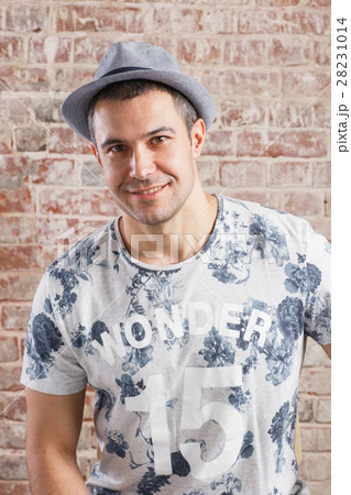 Trendy adult man portrait on background brick wall 28231014