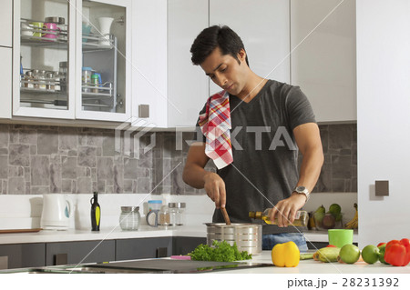 Young man cooking food in kitchen 28231392