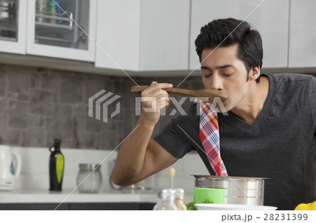Young man tasting soup 28231399