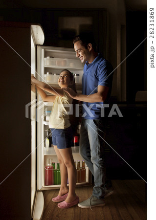 Father and daughter searching food in fridge at night Father and daughter searching food in fridge at night 28231869
