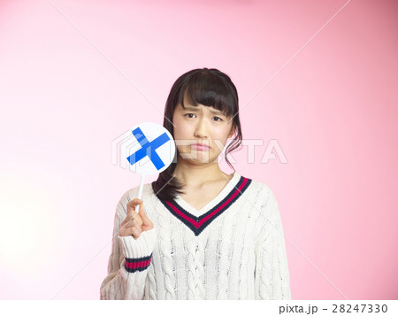 バッテンのプラカードを持ち渋い顔をする女の子 28247330