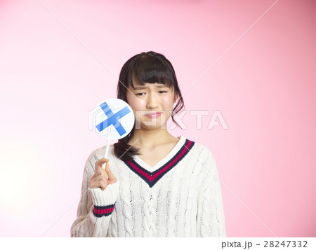 バッテンのプラカードを持ち渋い顔をする女の子 28247332