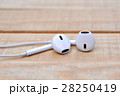 White headphones on wooden table 28250419