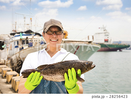 happy fisherman showing  fish before fishing ship 28256423