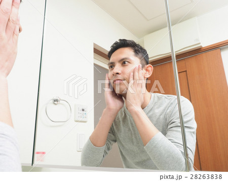 洗面所で頬に手を当てる若い男性の写真素材 28263838 Pixta