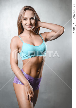 beautiful fitness model posing in studio on white grey backgroun 28268977