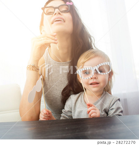 Mother and her daughter with a paper accessories. Mother and her daughter with a paper accessories. 28272270